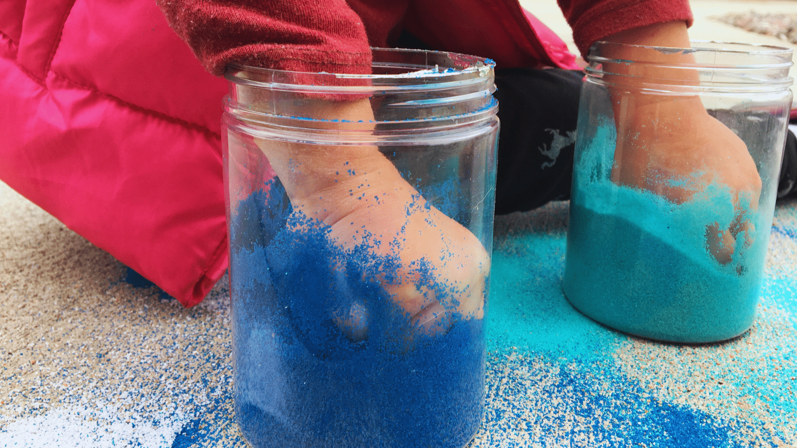 Child Playing With Jars of Sand