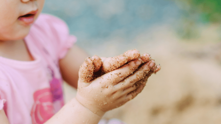 Toddler with Sand on Hands
